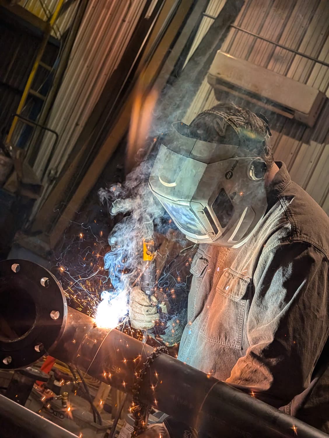Certified welder joining a flanged pipe spool